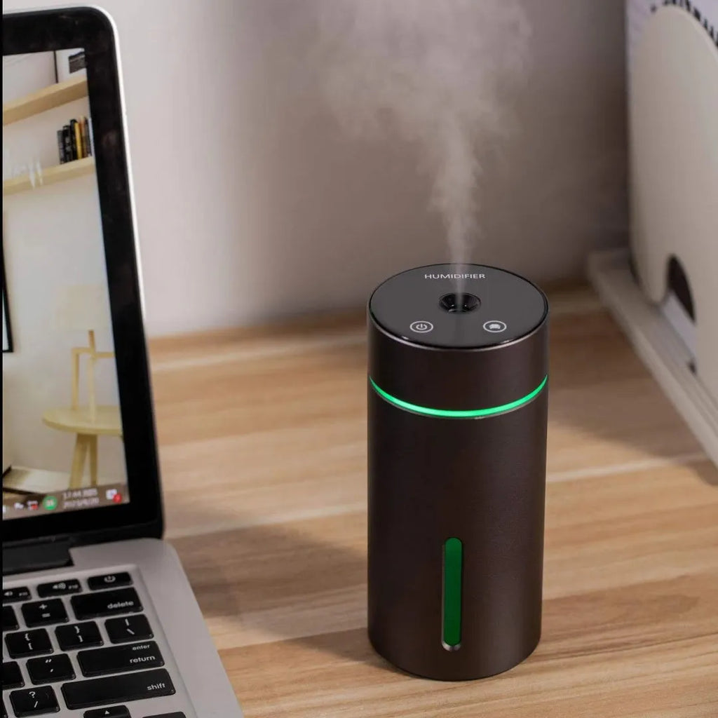 Compact aluminium car air humidifier and essential oil diffuser with night light on wooden desk