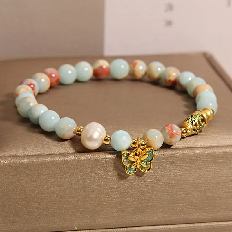 Blue women's bracelet with butterfly pendant containing Shoushan stone and freshwater pearls.