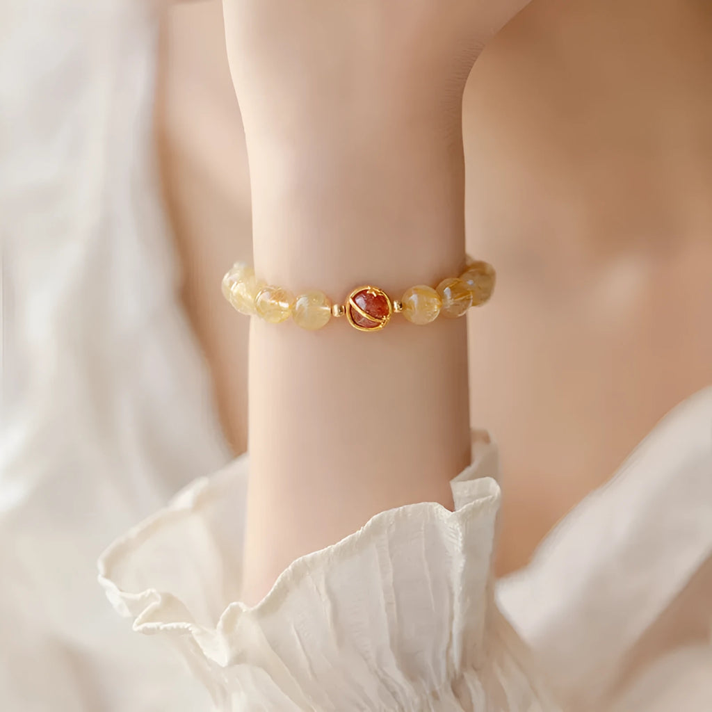 Gold rutilated quartz crystal bracelet with diamond-cut beads in a Korean-style design.