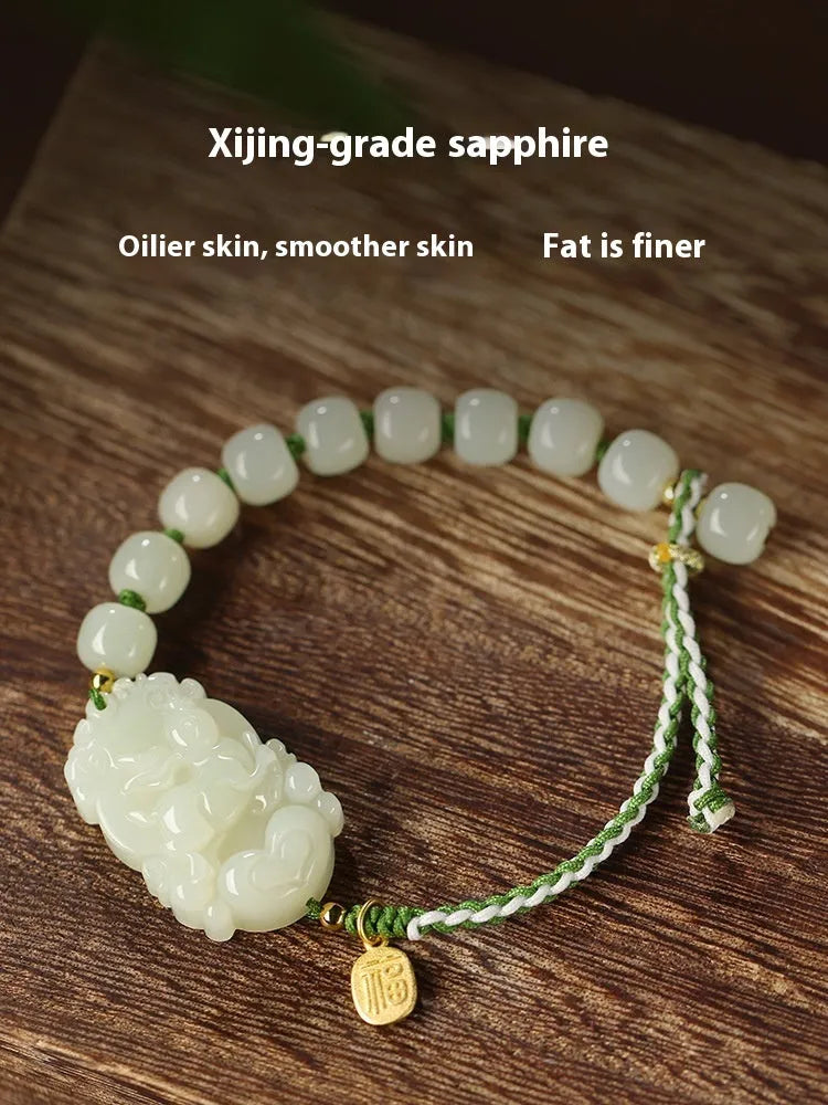 Hetian jade Rabbit charm bracelet on a red rope with a small silver blessing card.
