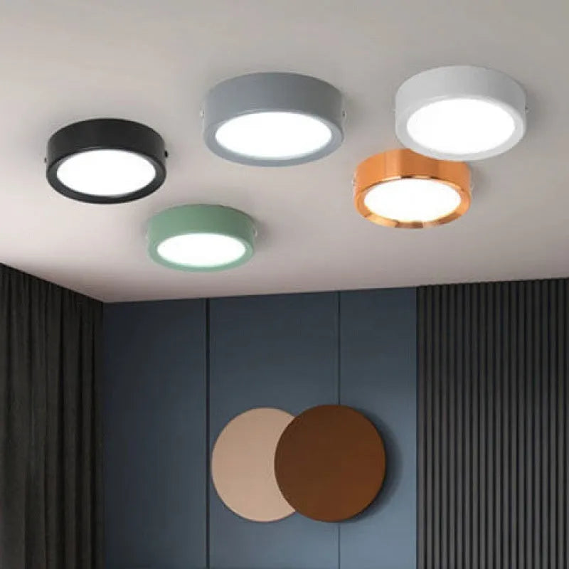 Ultra-thin surface mounted LED downlight in a choice of seven colours including black, white, gold, and pink.