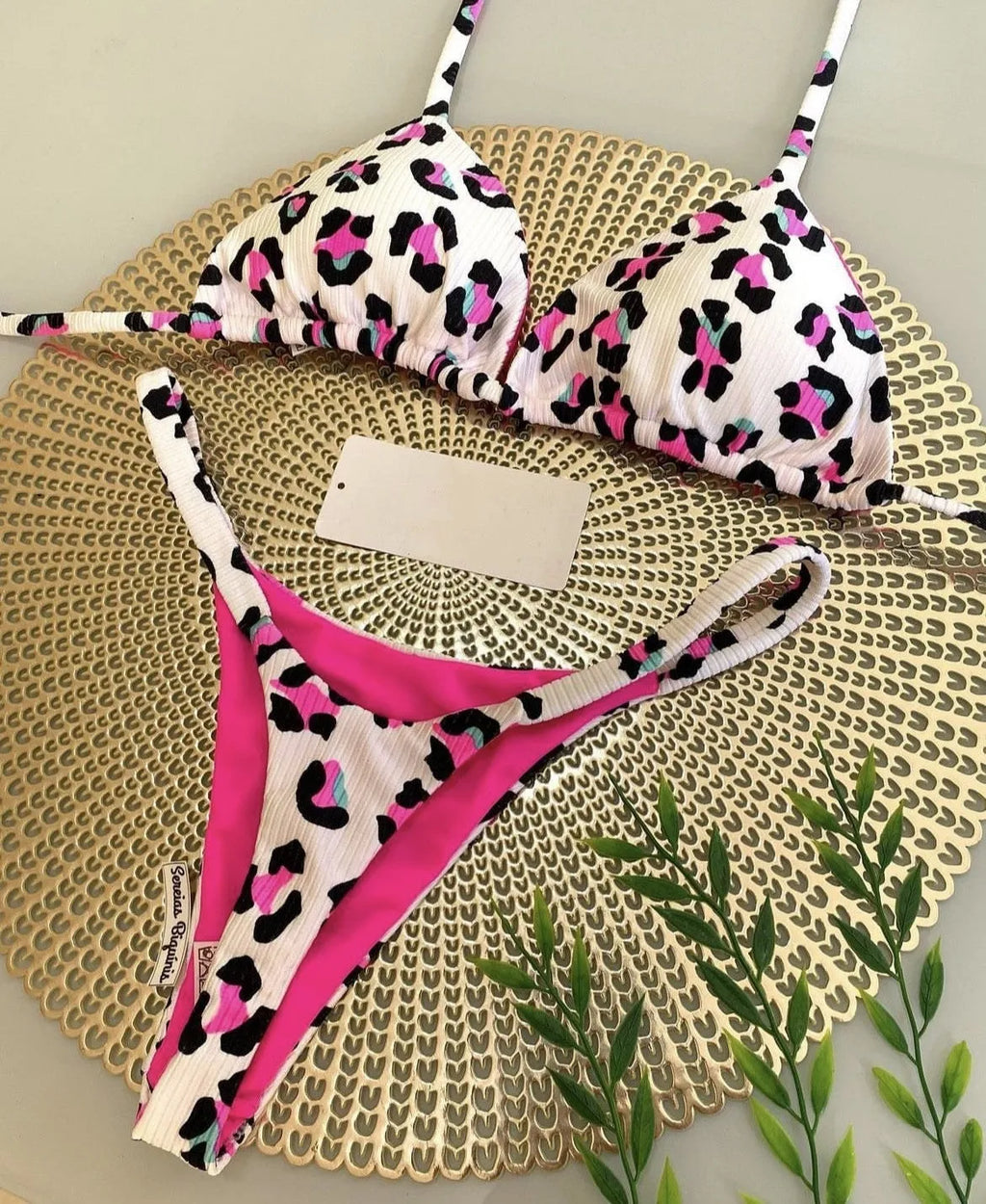 Women's printed bikini swimsuit on a hanger, showing briefs style with quick-drying fabric and cotton lining.