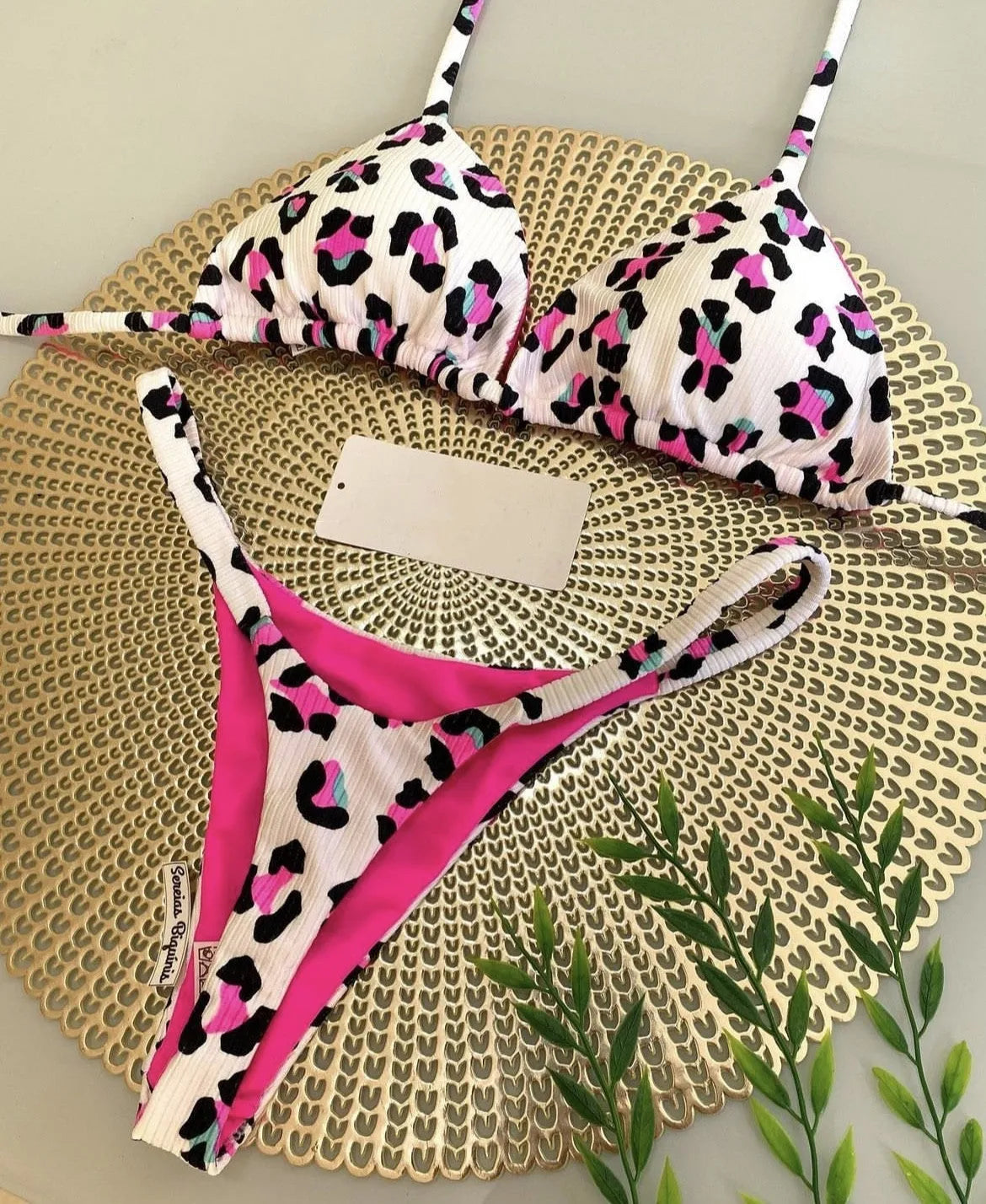 Women's printed bikini swimsuit on a hanger, showing briefs style with quick-drying fabric and cotton lining.