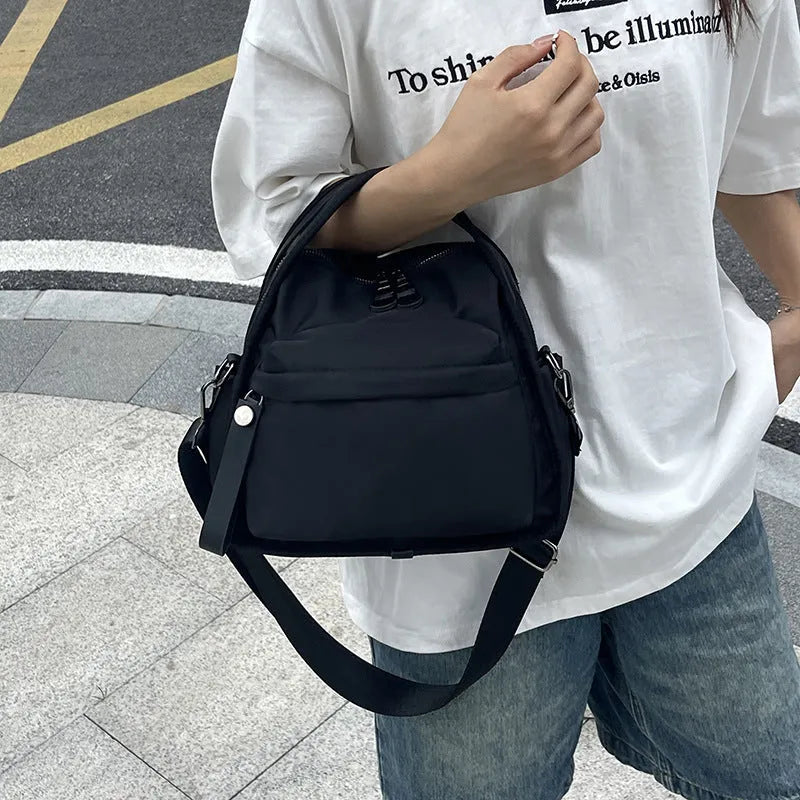 Nylon shoulder bag 25x11x23cm pillow shape with zippered compartment and outer pocket, available in brown, khaki, black, beige