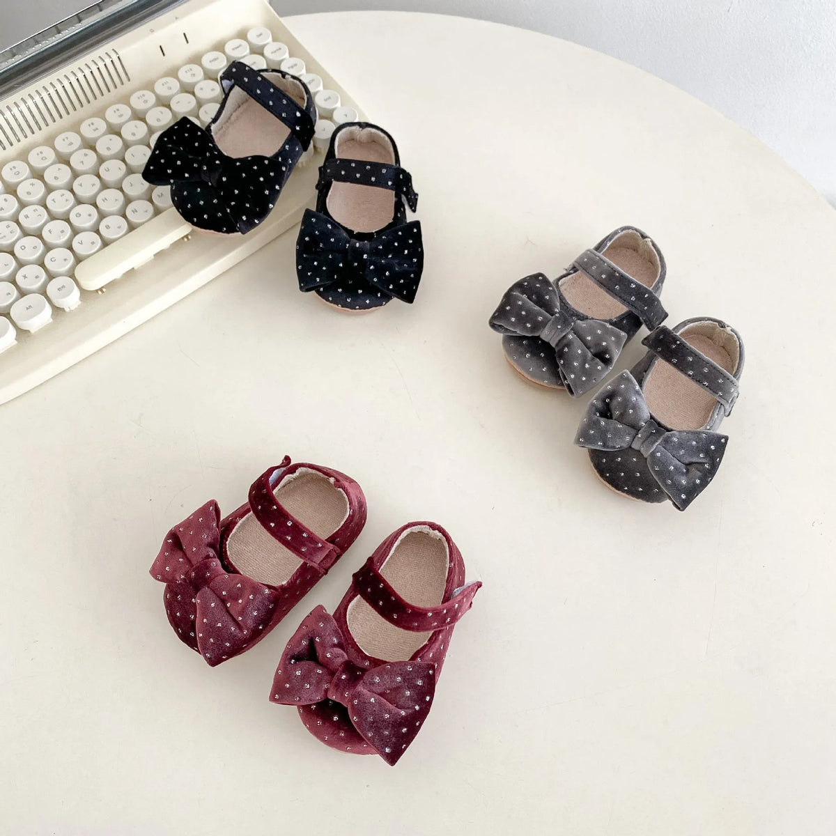 Baby girl toddler shoes with big bow and dots pattern in black on white background