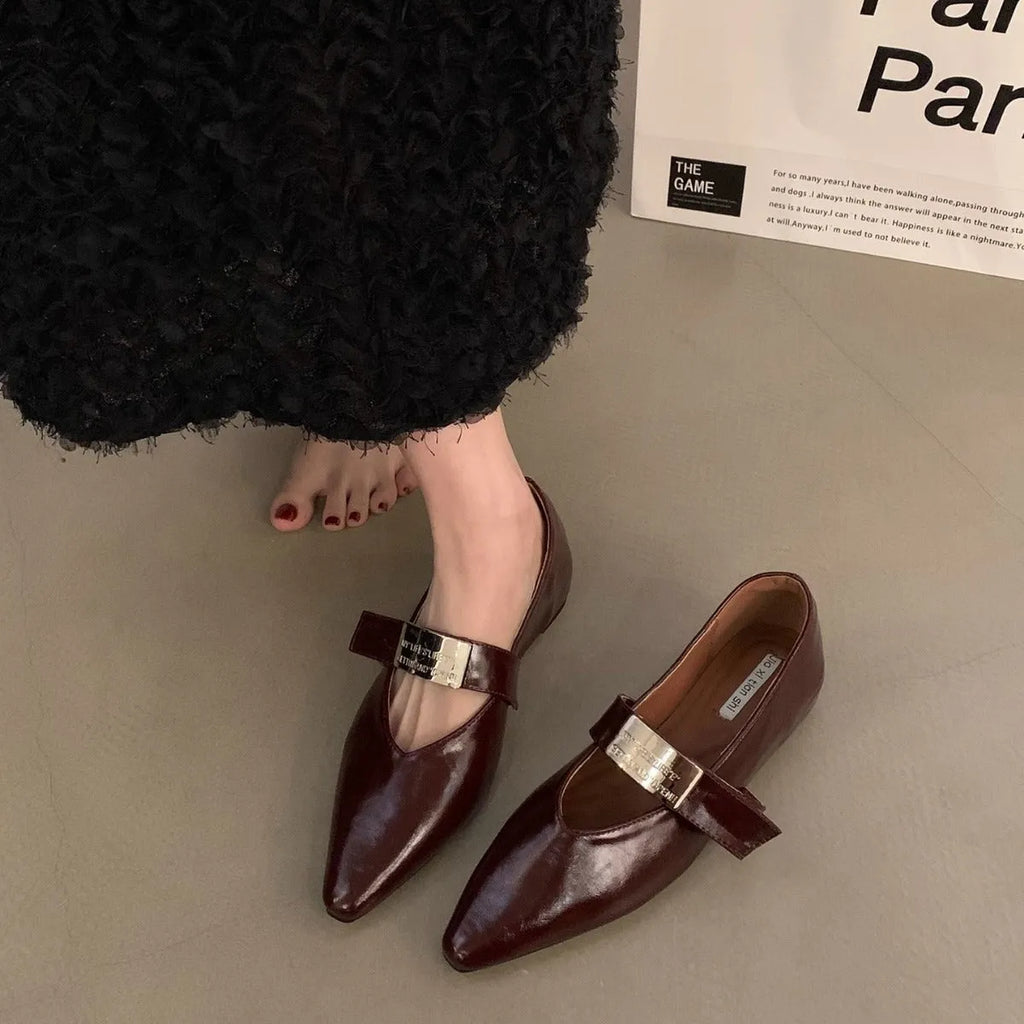 Women's black Mary Jane shoes with pointed toe, silver buckle, and low heel