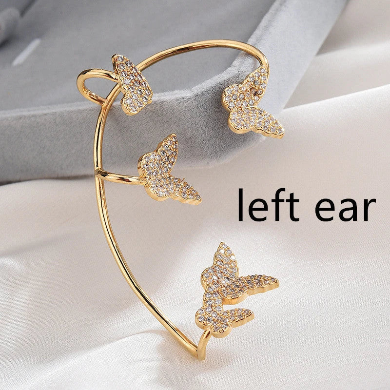 Sparkling zircon butterfly ear cuffs in gold-toned metal, featuring a delicate and elegant design for stylish accessorizing