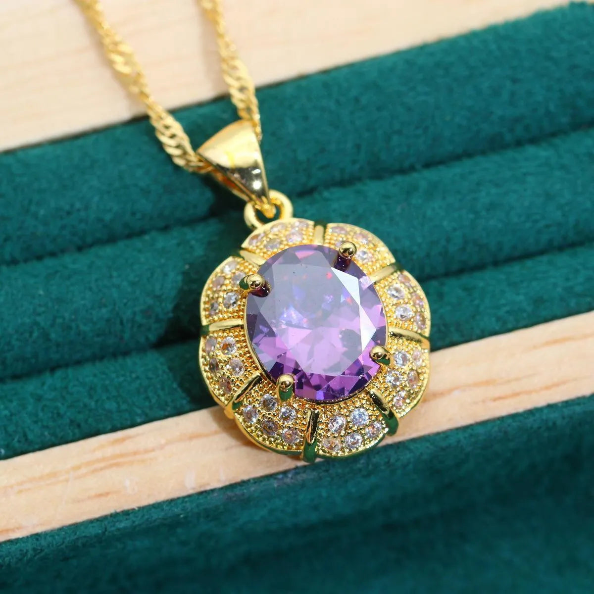 Gold-coloured jewellery set with sparkling blue cubic zirconia stones, showing necklace, earrings, ring, and bracelet.