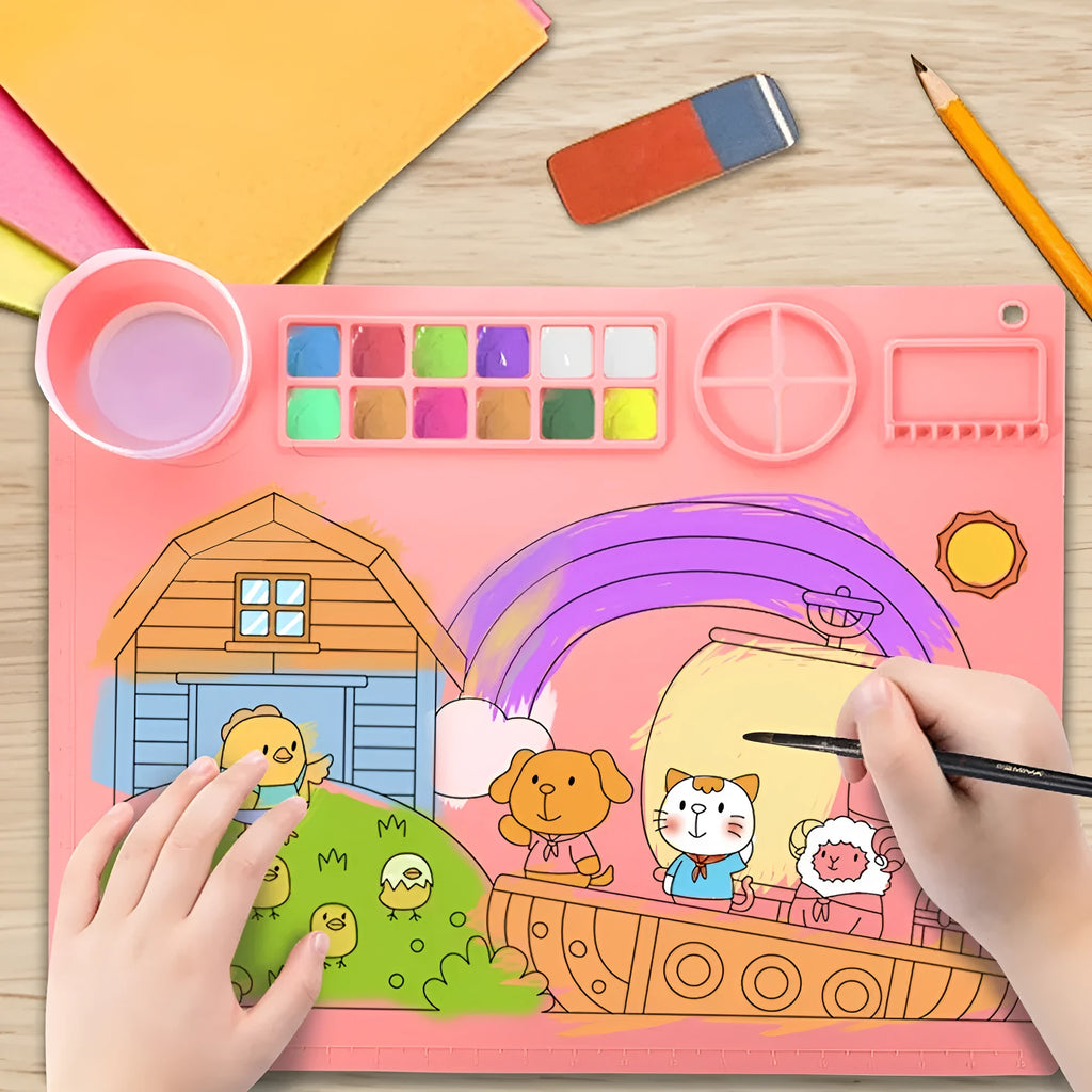 Light blue silicone painting mat with two integrated round bowls, laid flat on a wooden table.