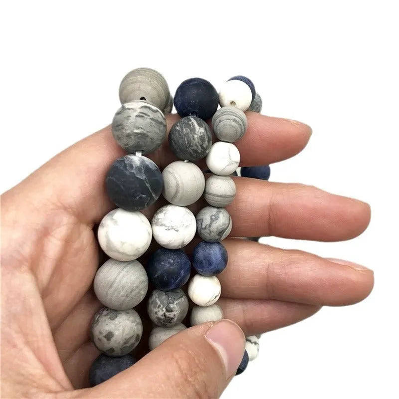 Handmade planet stone U-shaped bracelet with universe wind design on a wrist.