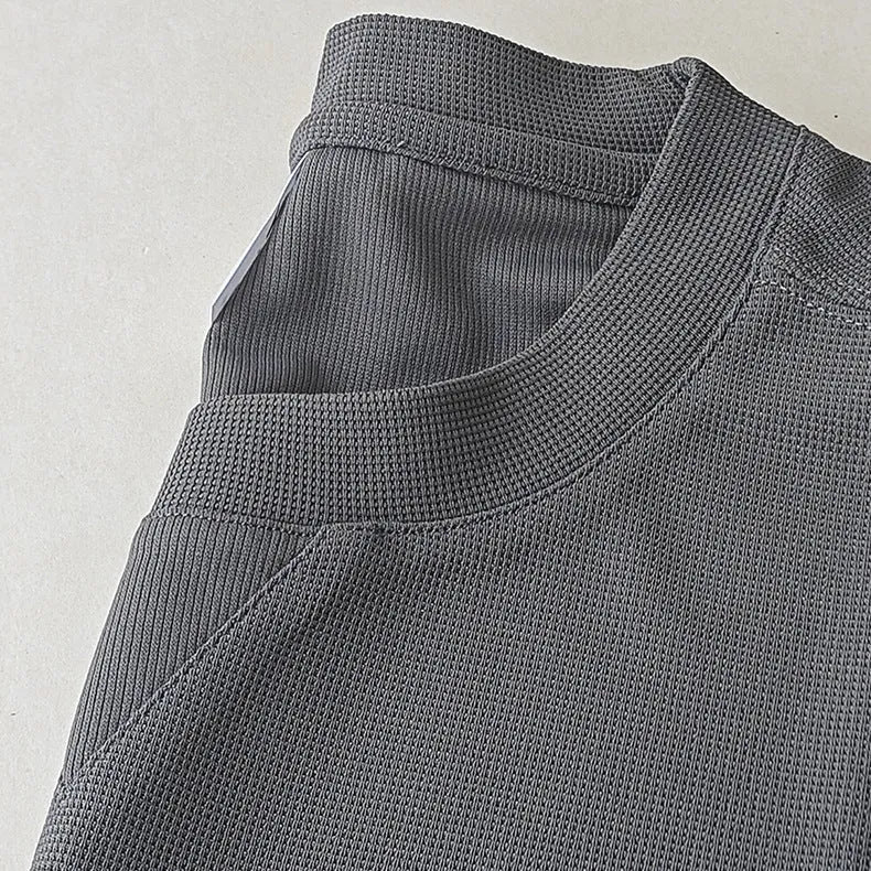 Men's dark grey heavy waffle knit short-sleeved t-shirt on a hanger.