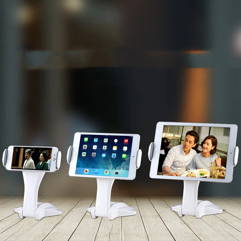 White adjustable tablet support stand with clip extended, holding a tablet on a desk.