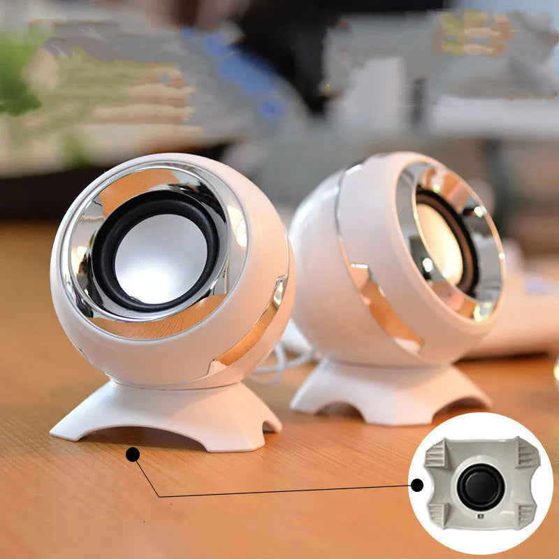 Compact black and gold USB-powered desktop stereo speakers next to a laptop.