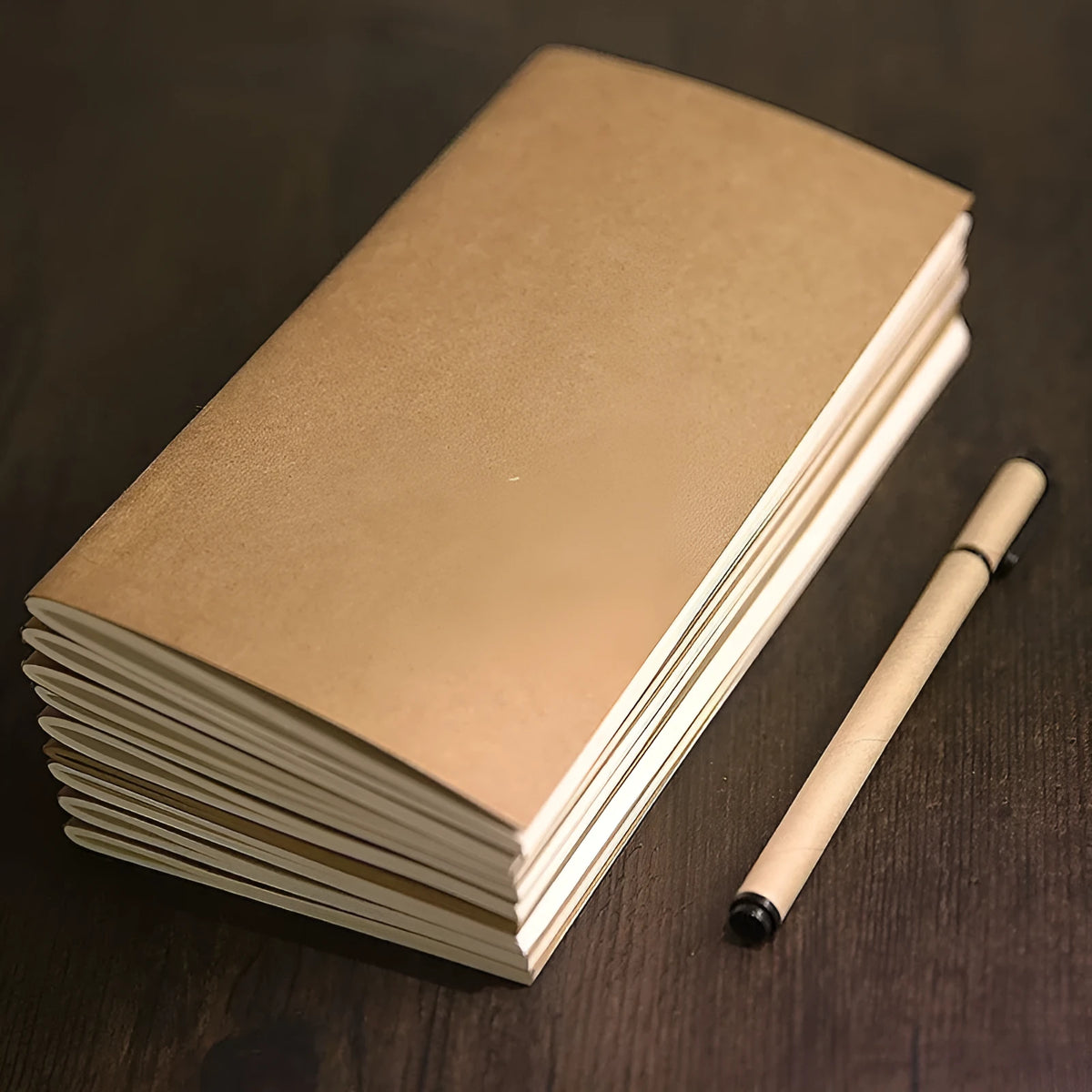 A5 kraft paper travel diary notebook with saddle stitching, open to show lined pages, on a wooden surface