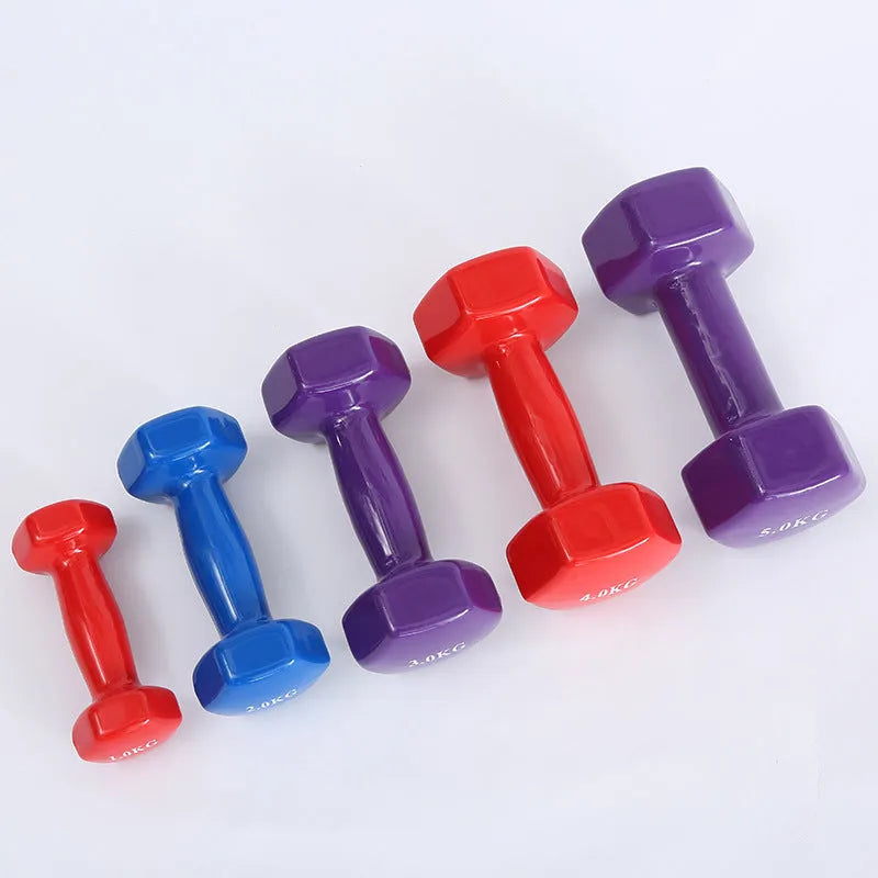 Brightly coloured plastic fitness dumbbells on a floor, showing glossy surface and multiple weight options.