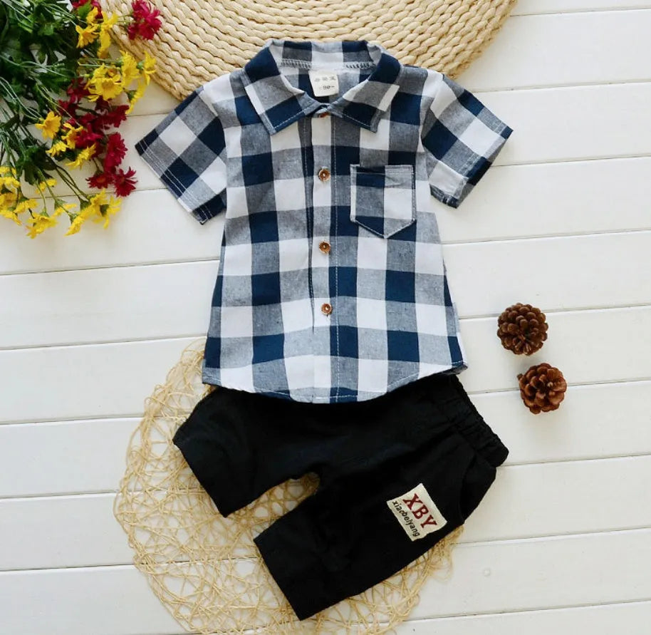 Baby boy wearing a blue cotton short sleeve T-shirt and matching shorts summer outfit set.