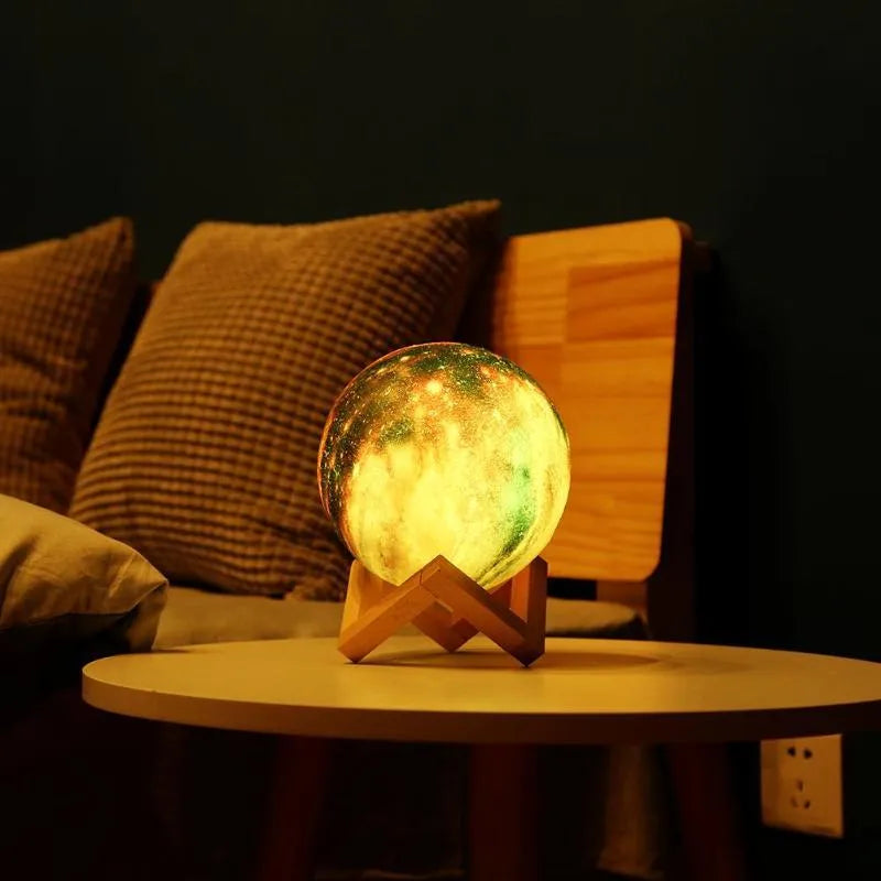 3D-printed spherical lunar night light with remote control on a dark surface.