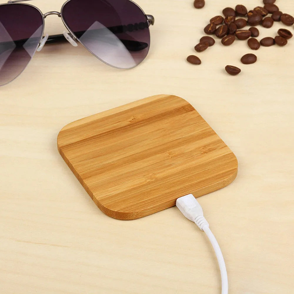 Brown heart-shaped wooden bamboo 5W Qi wireless charging pad on a desk