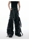 Black loose fit trousers with multi-pocket stitching and ribbon leather detailing on heavy composite fabric