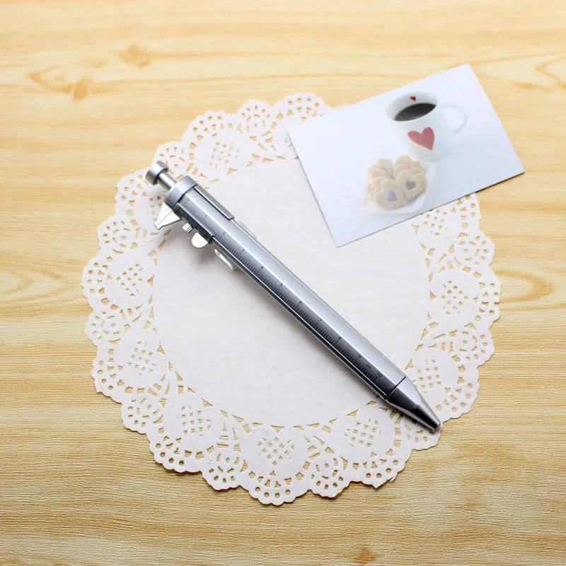 Orange multifunction ballpoint pen with integrated black vernier caliper scale, 15cm long.