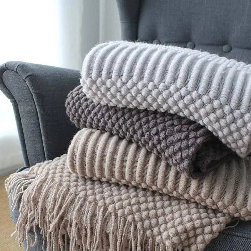 Small grey polyester nap blanket folded, showing its 127x170 cm size on a sofa.