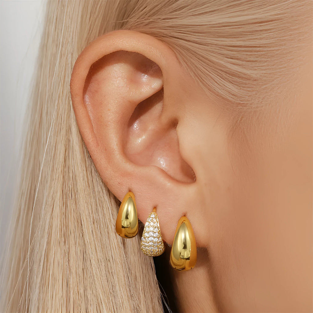 A pair of round geometric brass clip earrings with a gold electroplated finish on a white background.