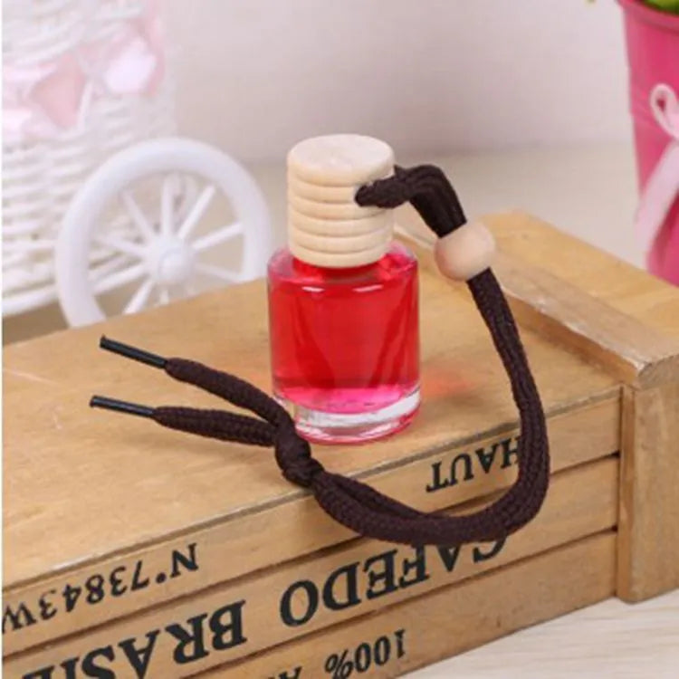 Glass bottle car air freshener hanging ornament showing six fragrance options: lavender, lemon, apple, strawberry, ocean, and floral
