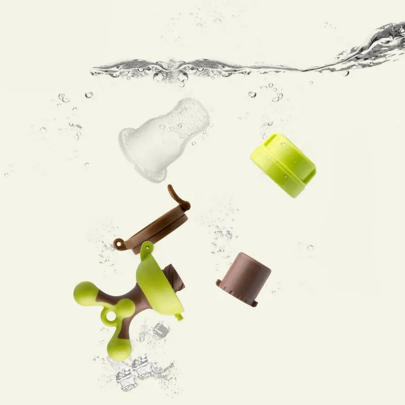 Green and purple silicone baby teether with textured chewing surfaces and a central handle.