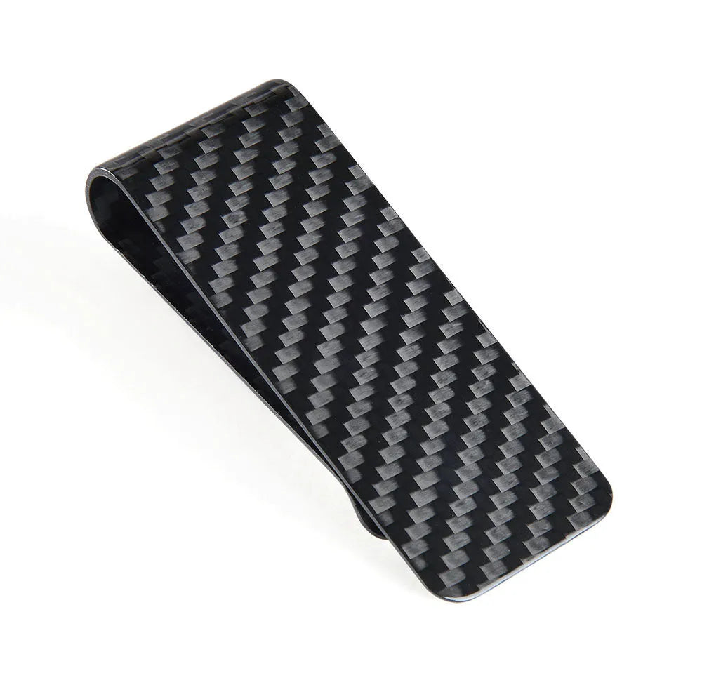 Black glossy striped carbon fibre money clip on a flat surface showing its slim profile and textured pattern