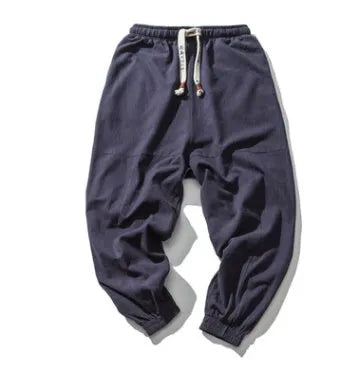 Men's cotton harem joggers in black with drawstring waist, two slant pockets, and tapered ribbed ankle.