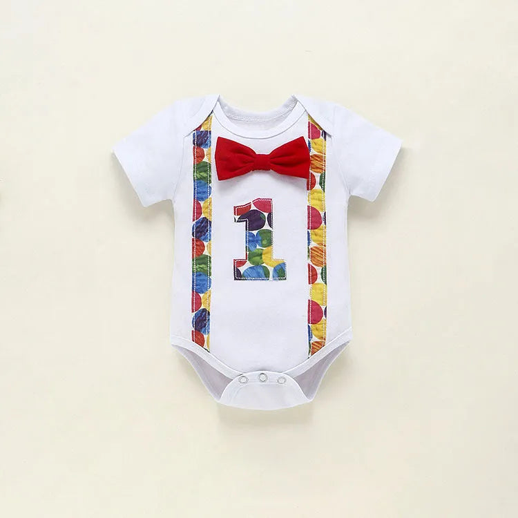Baby wearing a blue cotton romper with shorts, a bow, and dinosaur print details.