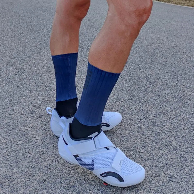 A pair of breathable cycling and running socks in an orange colour on a plain background.