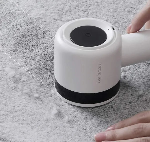 White rechargeable lint remover with hidden hair collection container and detachable three-blade head on white background