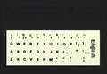 Yellow PVC sheet of glow-in-the-dark keyboard stickers for Arabic, Thai, Hebrew, French, Italian, and German layouts.
