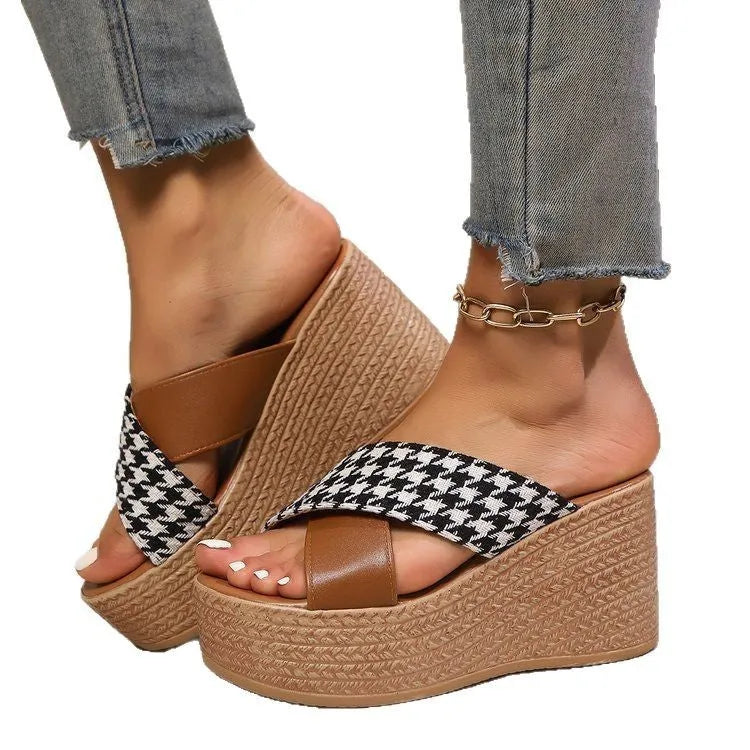 Brown and black plaid pattern wedge sandals with a rubber sole on a white background.