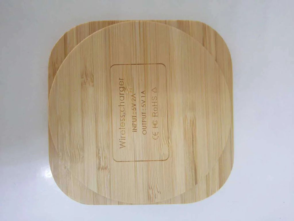 Brown heart-shaped wooden bamboo 5W Qi wireless charging pad on a desk
