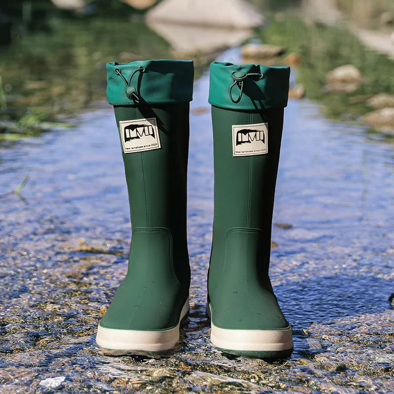 A pair of high tube PVC rain boots in a solid colour, shown on a non-slip sole.