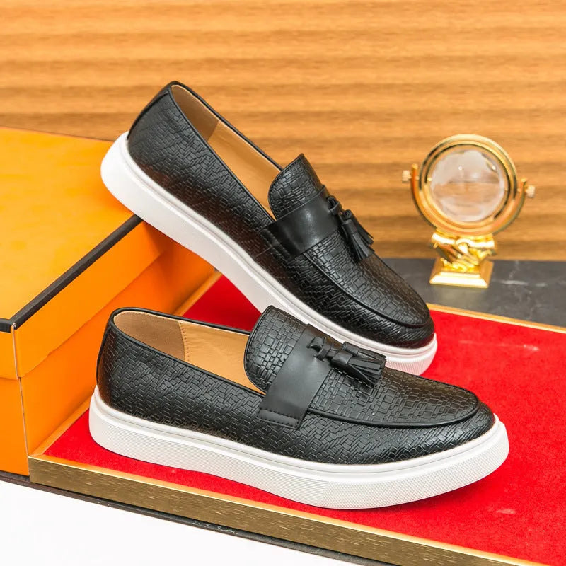 Men's black casual leather shoes with fringe detail on round toe, showing low heel profile.