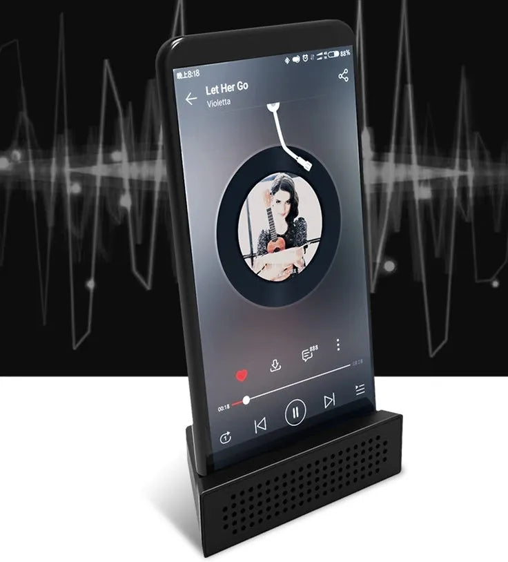 Mini black ABS plastic mobile phone amplifier bracket holding an iPhone on a desktop.