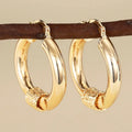 Geometric gold-coloured copper earrings with ring and line design elements