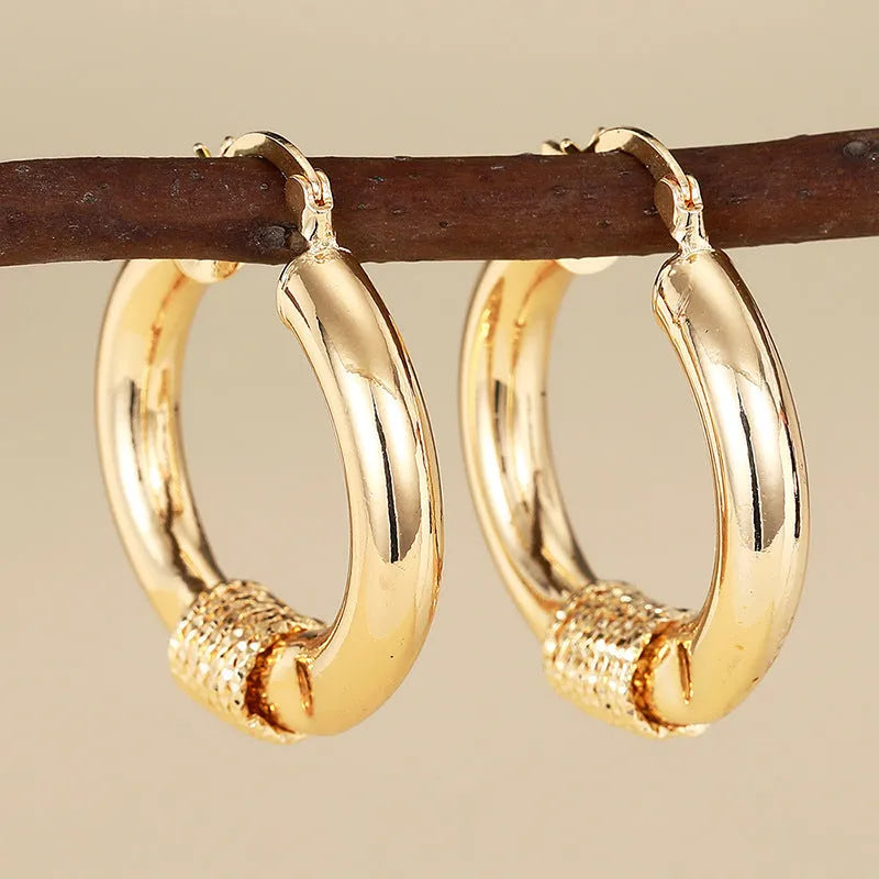 Geometric gold-coloured copper earrings with ring and line design elements