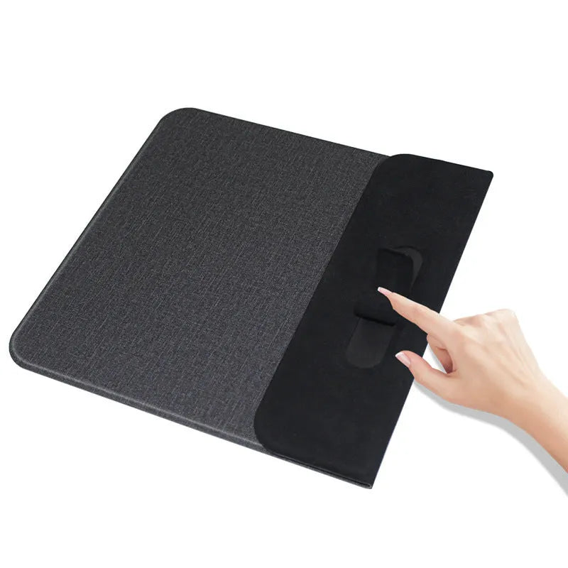 Black 2-in-1 wireless charging mouse pad on a desk with a phone resting on the built-in bracket