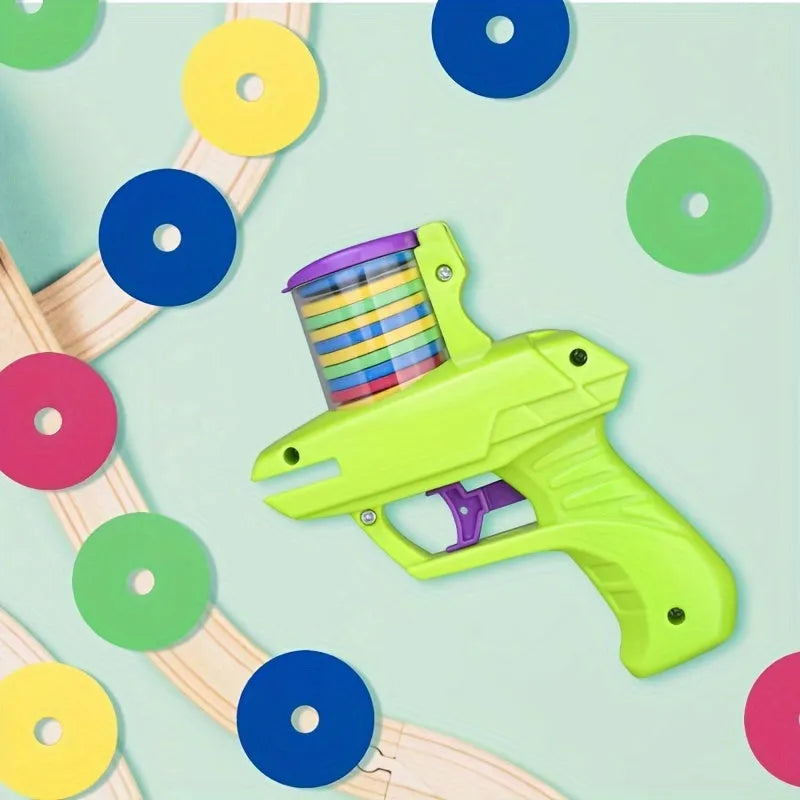 Green durable plastic manual cat toy launcher with a stack of soft foam discs on a floor.