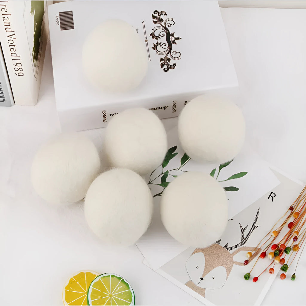 A wool drying ball for laundry next to a plain cotton storage bag on a background.