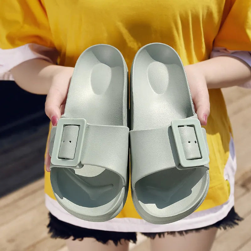 Women's grey blue flip-flop slippers with a buckle strap and soft EVA sole on a light background.