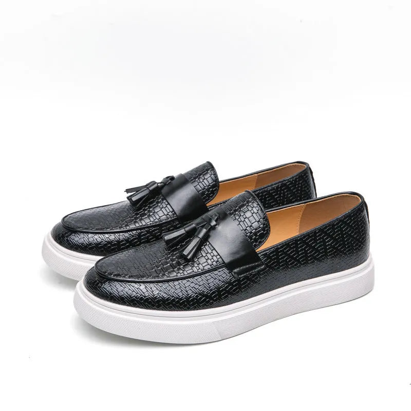 Men's black casual leather shoes with fringe detail on round toe, showing low heel profile.