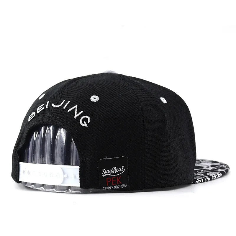 Black and white adjustable cotton baseball cap with embroidered lettering and dome crown.