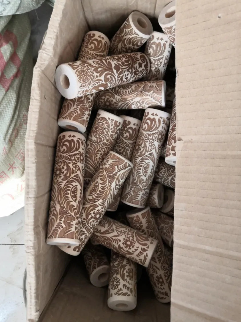 Wooden rolling pin with embossed Christmas patterns, 45cm long, on a kitchen worktop.