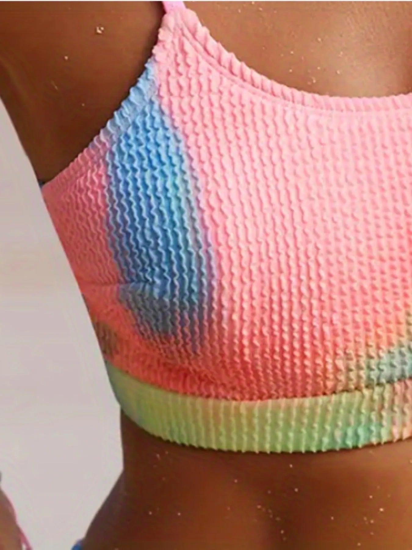 Women's blue and orange tie-dye gradient pattern bikini briefs on a white background.