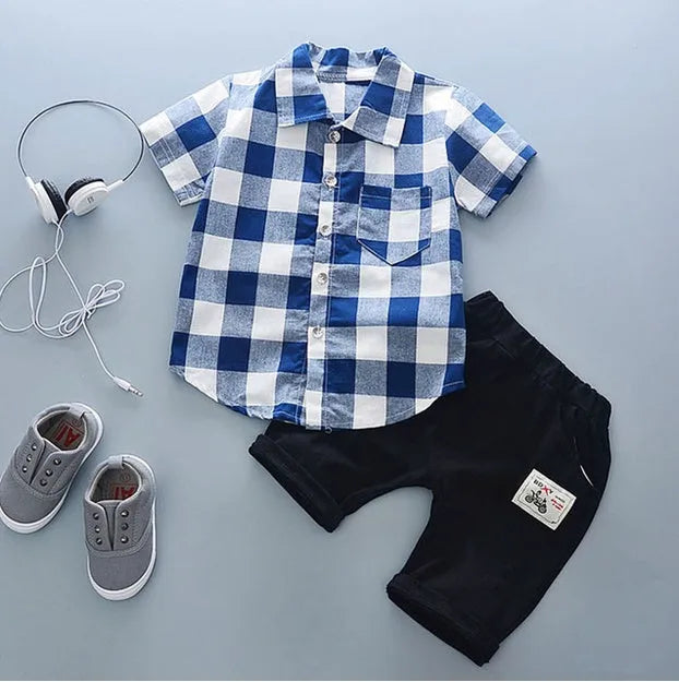Baby boy wearing a blue cotton short sleeve T-shirt and matching shorts summer outfit set.